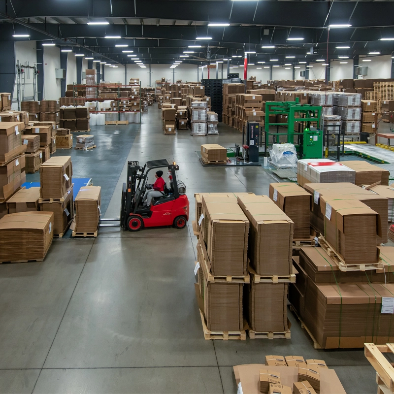 Large Landaal warehouse with many stacks of corrugate and a forklift moving pallets