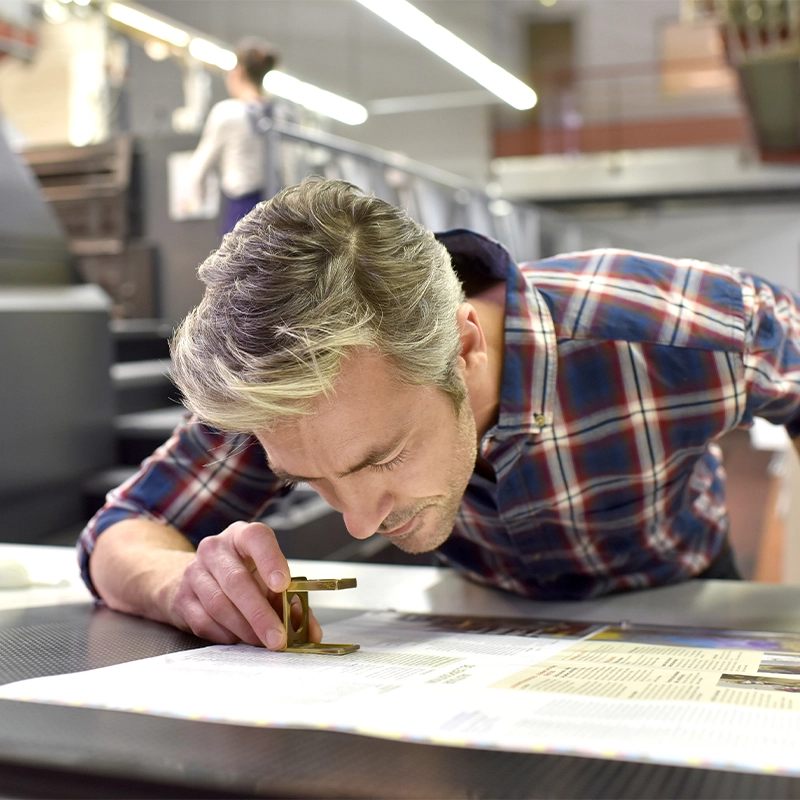 Landaal employee inspecting printed items for quality